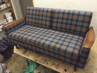 Wooden-framed bench sofa with blue and brown check upholstery in the workshop