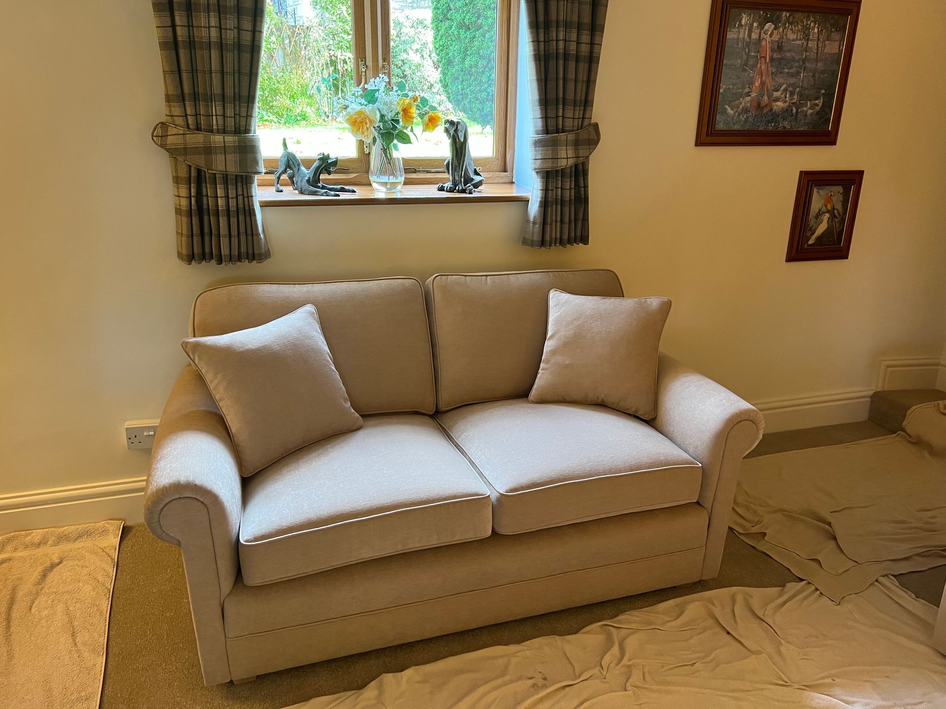 Cream two-seat sofa in a bright living room by a bay window