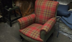 Traditional wingback armchair in red tartan fabric in the workshop